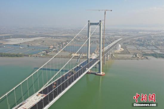 1月30日，粤港澳大湾区又一重要过江通道虎门二桥项目的两座主桥钢桥面环氧沥青铺装工程完成，预计今年5月1日前通车。当天，虎门二桥大沙水道桥的桥面上机械轰鸣，两台摊铺机缓缓驶离沥青面，七台震荡压路机对该桥左幅环氧沥青的上面层施工进行最后一道循环碾压工序。<a target='_blank' href='http://www.chinanews.com/'>中新社</a>发 岳路建 摄